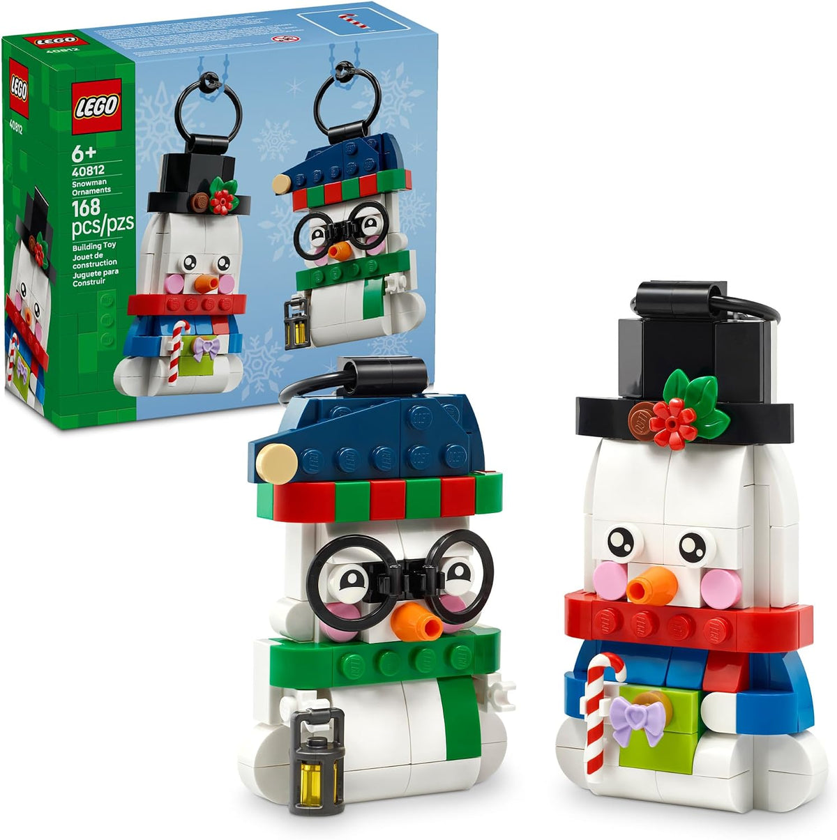 two snowman figures: taller one with top hat, candy cane, and gift; shorter one with glasses, beanie, and lantern